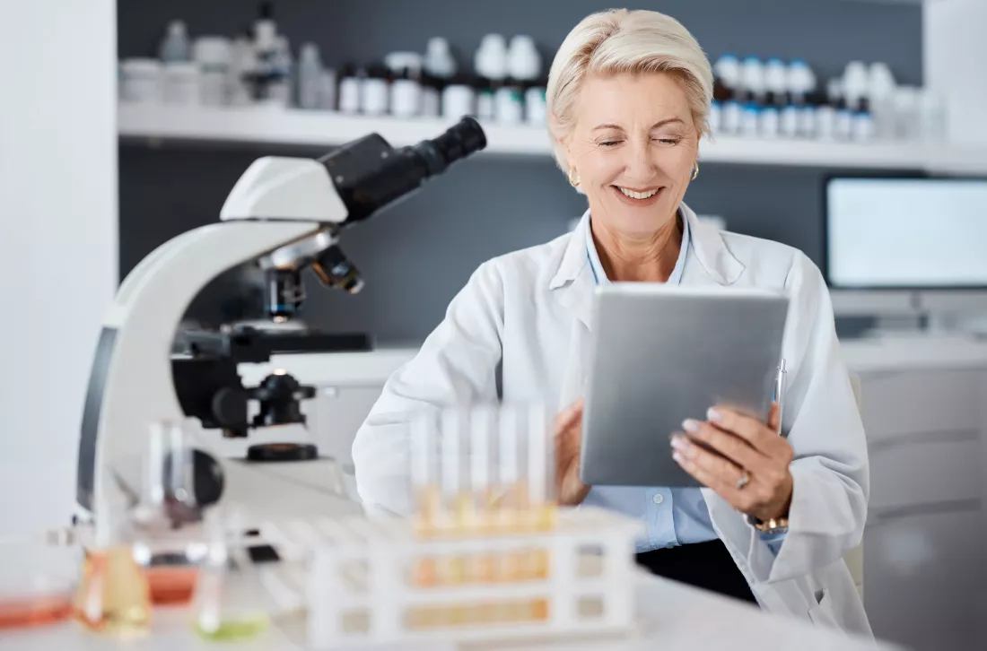 science-tablet-research-woman-with-microscope-data-analytics-test-results-laboratory-software-management-biotechnology-medicine-digital-healthcare-expert-scientist-senior-person