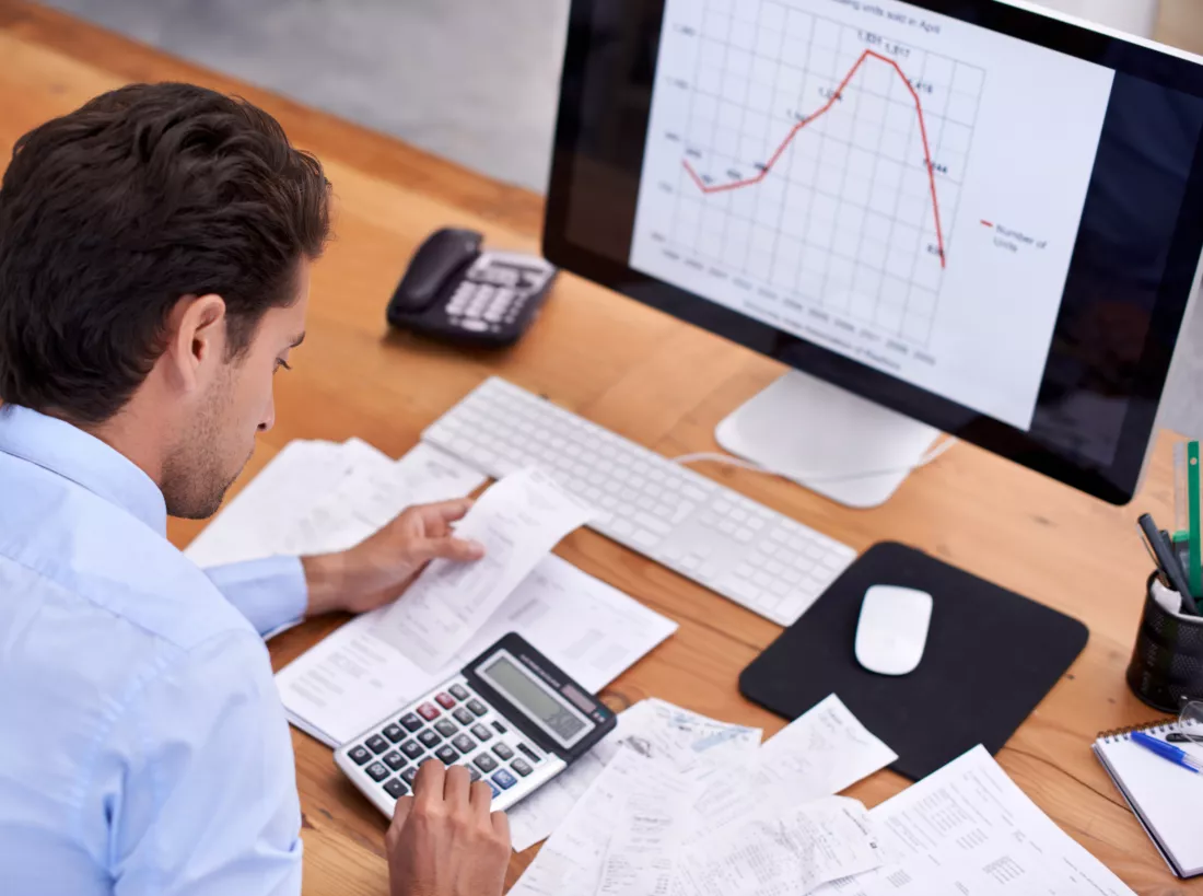 crunching-numbers-rearview-shot-handsome-young-businessman-working-his-desk